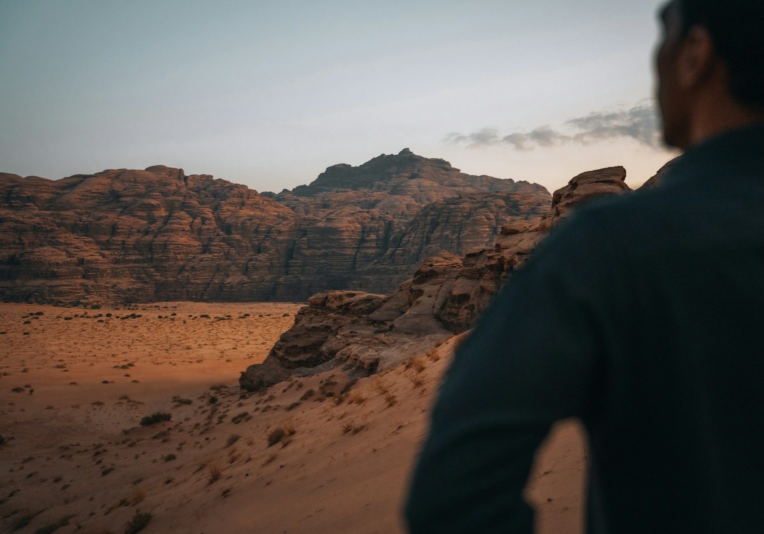 a man standing on top of a sandy hill